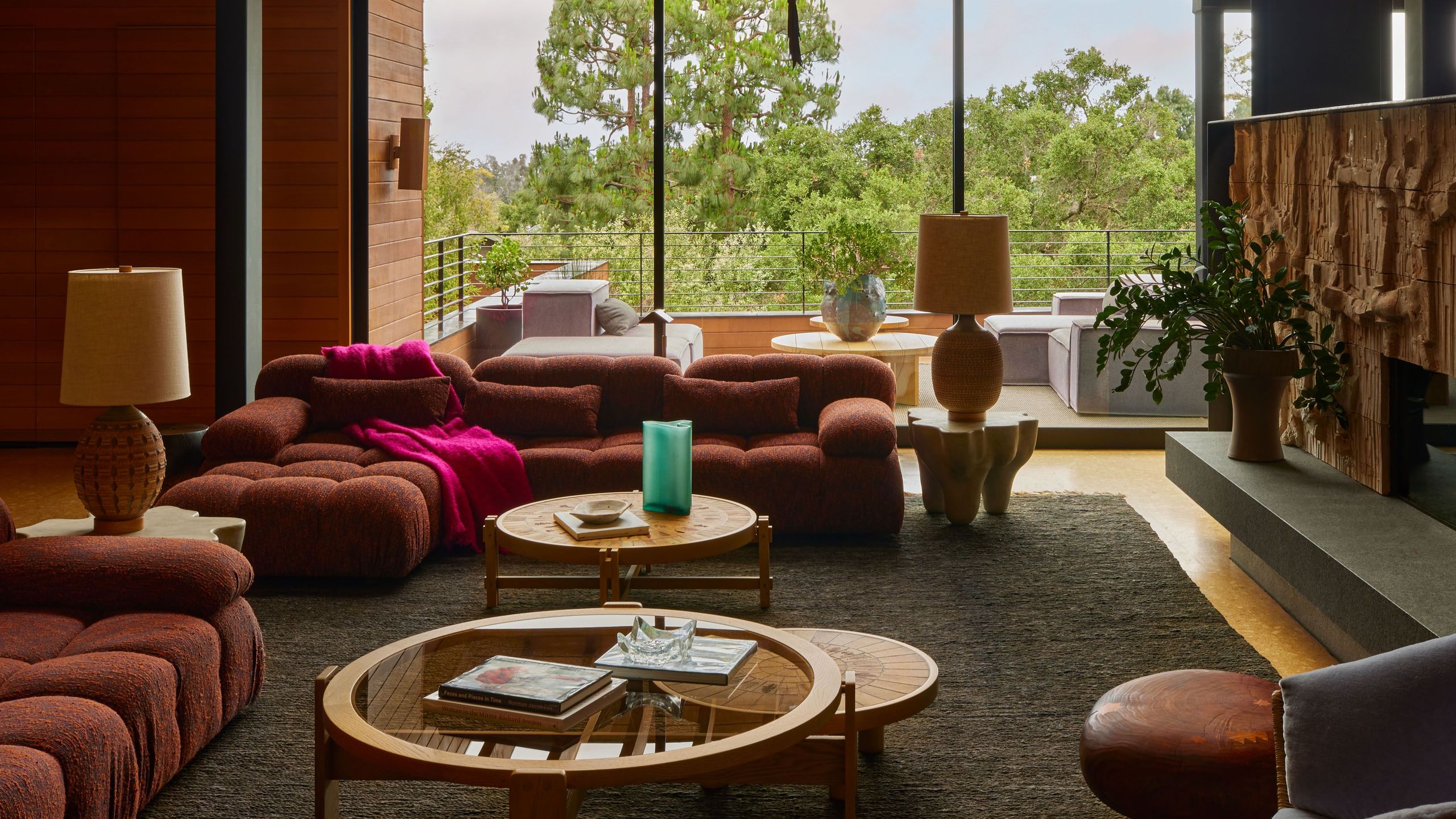 Wood paneled living room with large sofas and a light fixture made up of paper lanterns.